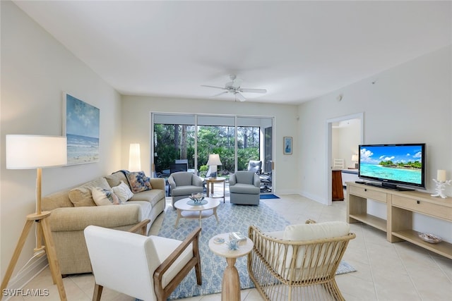 living room with light tile patterned floors, ceiling fan, and baseboards