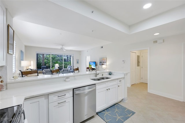 kitchen featuring open floor plan, stainless steel dishwasher, a sink, and white cabinets