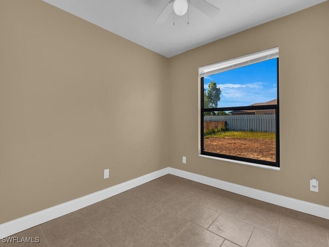 tiled spare room with ceiling fan