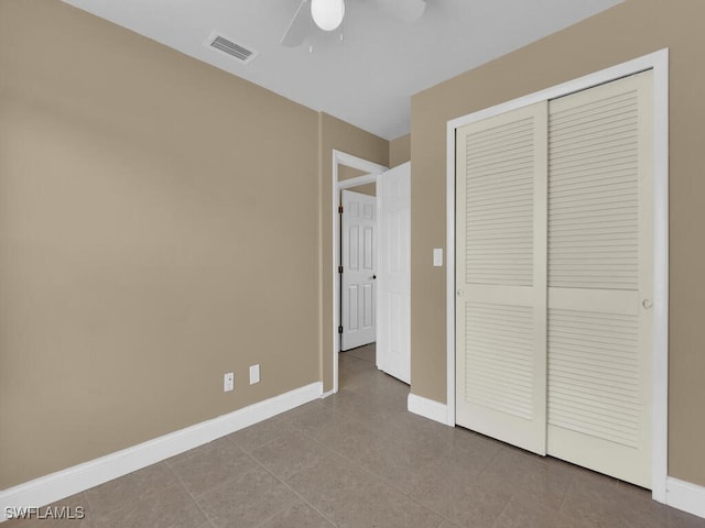 unfurnished bedroom featuring ceiling fan, a closet, and light tile patterned floors