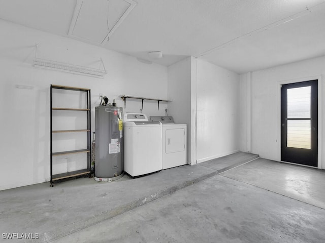 garage featuring electric water heater and separate washer and dryer