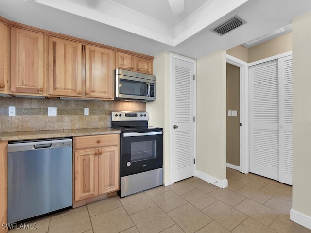 kitchen with decorative backsplash, appliances with stainless steel finishes, ornamental molding, a raised ceiling, and light tile patterned floors