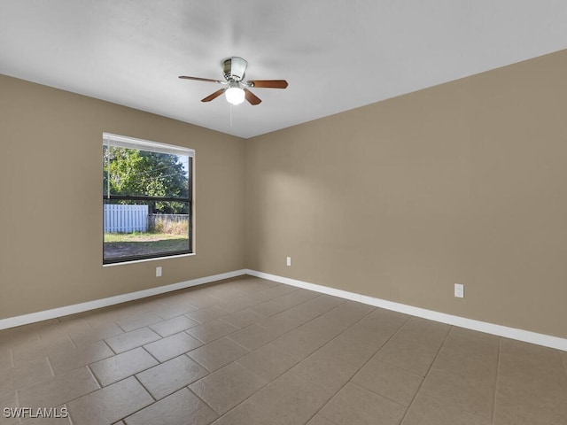 empty room with ceiling fan and light tile patterned flooring