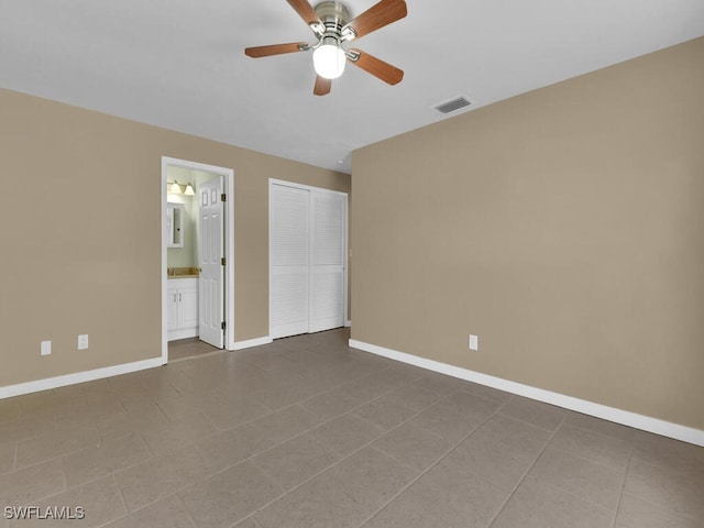 tiled spare room featuring ceiling fan