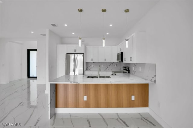 kitchen with backsplash, range, stainless steel fridge, white cabinetry, and kitchen peninsula