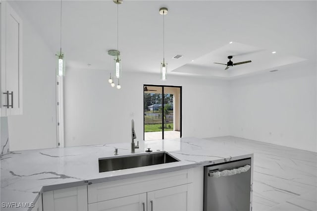 kitchen featuring a raised ceiling, sink, hanging light fixtures, stainless steel dishwasher, and white cabinetry