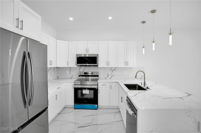 kitchen with appliances with stainless steel finishes, decorative light fixtures, and white cabinetry