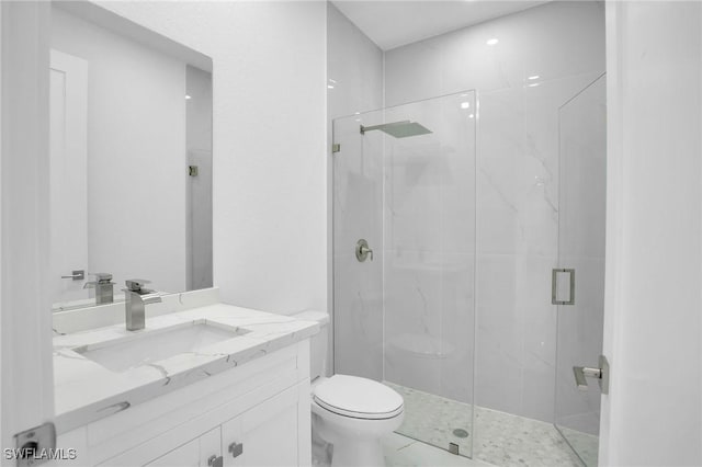 bathroom featuring vanity, a shower with shower door, and toilet