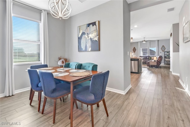 dining area featuring ceiling fan with notable chandelier and light hardwood / wood-style floors