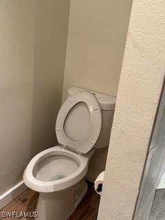 bathroom featuring wood-type flooring and toilet