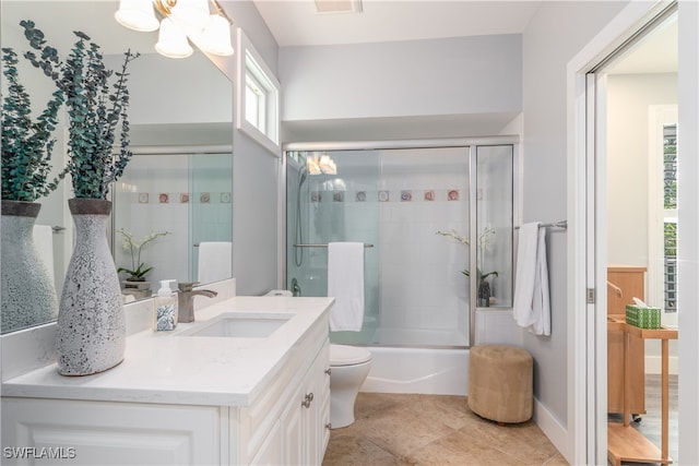 full bath featuring bath / shower combo with glass door, toilet, vanity, a chandelier, and tile patterned flooring