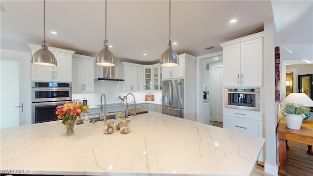 kitchen featuring white cabinetry, visible vents, stainless steel appliances, and decorative backsplash