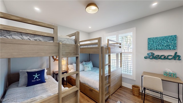 bedroom with baseboards, baseboard heating, wood finished floors, and recessed lighting