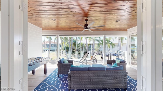 sunroom / solarium featuring a ceiling fan and wooden ceiling