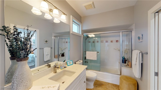 full bathroom featuring visible vents, toilet, an inviting chandelier, enclosed tub / shower combo, and vanity