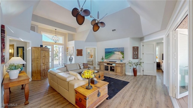 living area featuring light wood-type flooring, high vaulted ceiling, baseboards, and visible vents