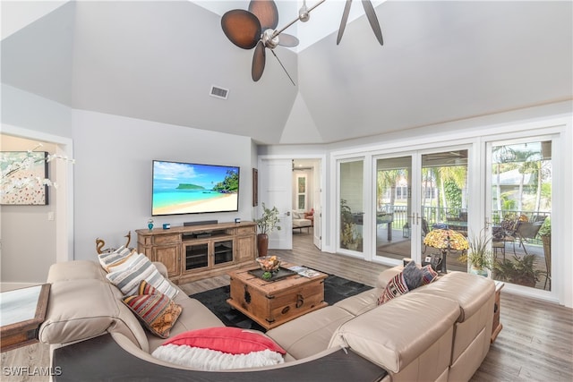 living area with ceiling fan, high vaulted ceiling, wood finished floors, and visible vents