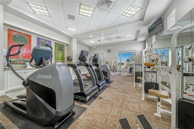 gym featuring a drop ceiling and light colored carpet