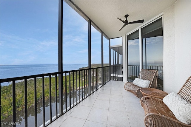 sunroom featuring ceiling fan, a water view, and a wealth of natural light