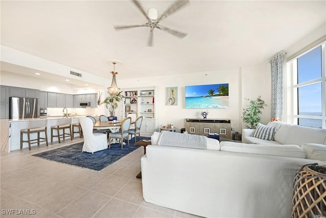 tiled living room featuring ceiling fan and sink