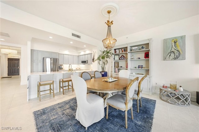 tiled dining room with sink and a chandelier