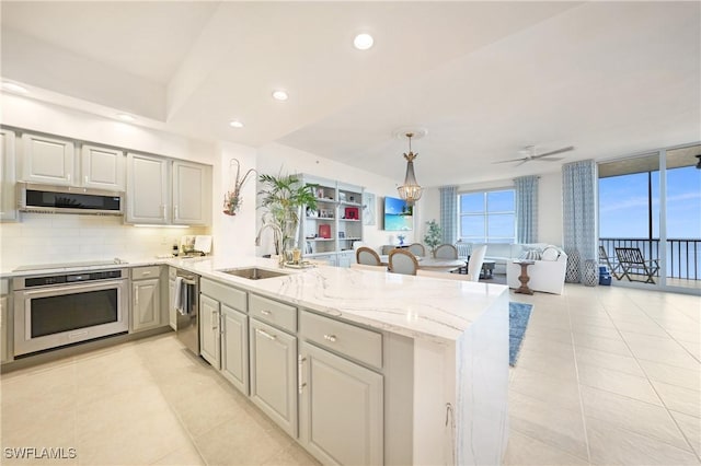 kitchen featuring sink, hanging light fixtures, ceiling fan, kitchen peninsula, and stainless steel appliances