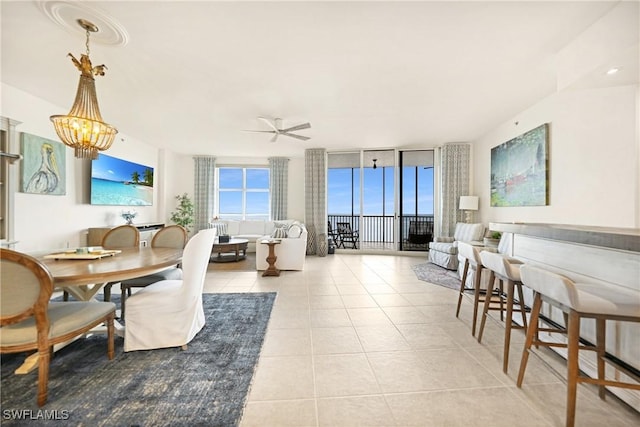 living room featuring ceiling fan with notable chandelier, floor to ceiling windows, and light tile patterned floors