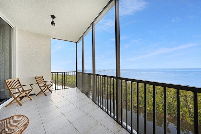 unfurnished sunroom featuring a water view