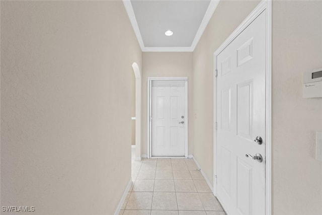 hallway with light tile patterned floors and crown molding