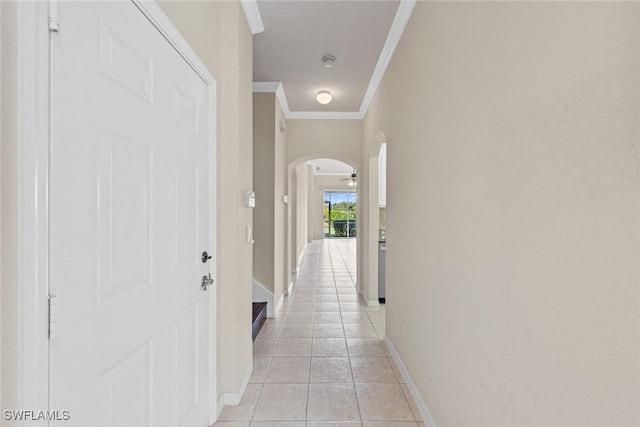 hallway with light tile patterned floors and crown molding