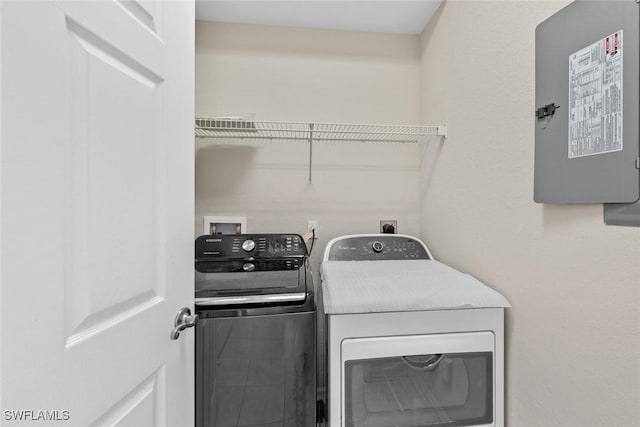 laundry room featuring electric panel and separate washer and dryer