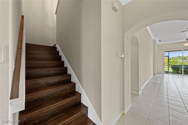 stairs featuring tile patterned floors and crown molding