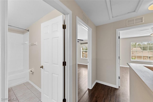 hallway featuring light tile patterned floors and a healthy amount of sunlight