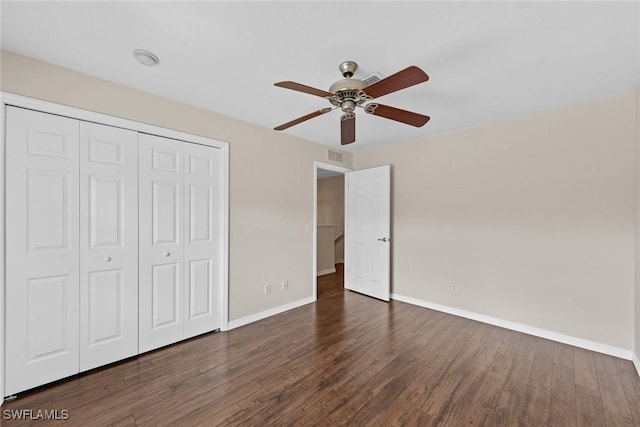 unfurnished bedroom with ceiling fan, dark hardwood / wood-style floors, and a closet