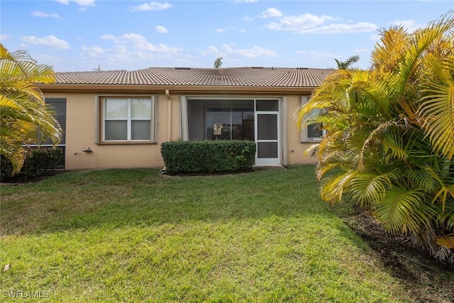 rear view of property with a lawn