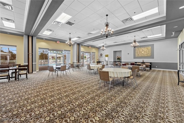 carpeted dining room featuring a tray ceiling and a drop ceiling