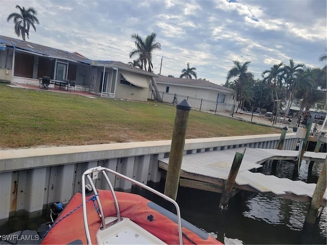 view of dock featuring a lawn and a water view