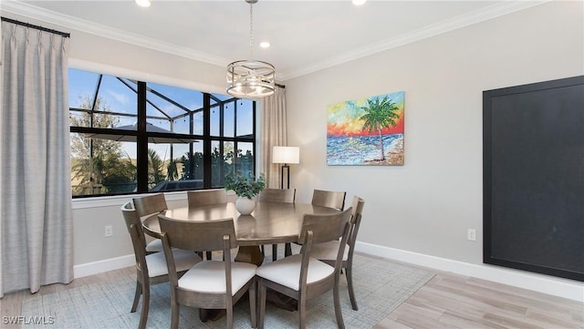 dining area with a chandelier, light hardwood / wood-style flooring, and ornamental molding