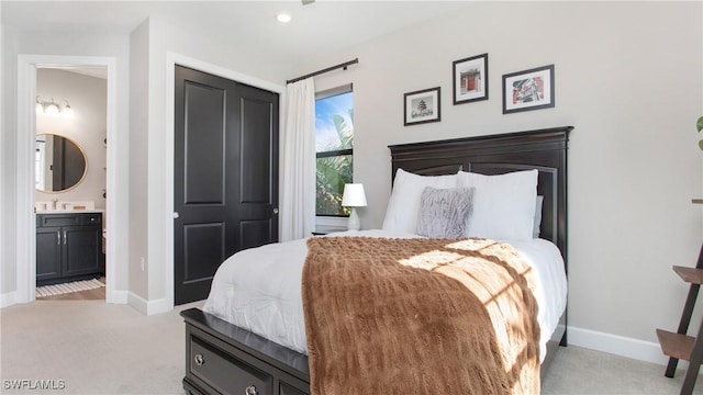 bedroom with light carpet, connected bathroom, and sink