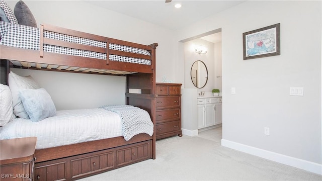 bedroom featuring light carpet and ensuite bath