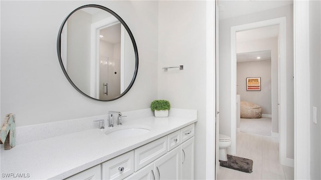 bathroom featuring tile patterned floors, vanity, and toilet