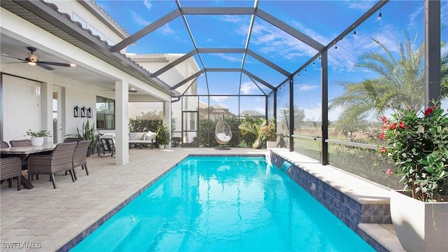 view of swimming pool with outdoor lounge area, ceiling fan, a lanai, pool water feature, and a patio