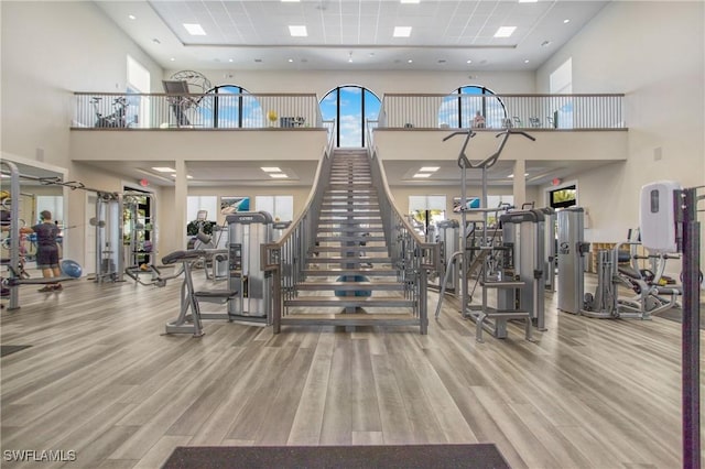 workout area with a towering ceiling and hardwood / wood-style flooring