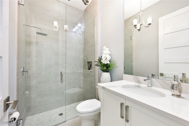 bathroom featuring vanity, toilet, an inviting chandelier, and a shower stall