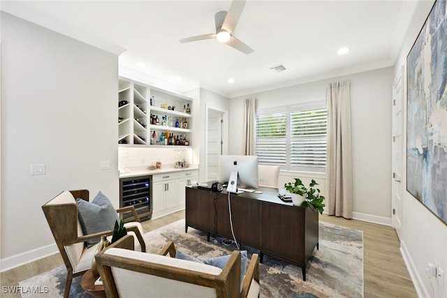 home office with visible vents, light wood finished floors, ornamental molding, a bar, and wine cooler