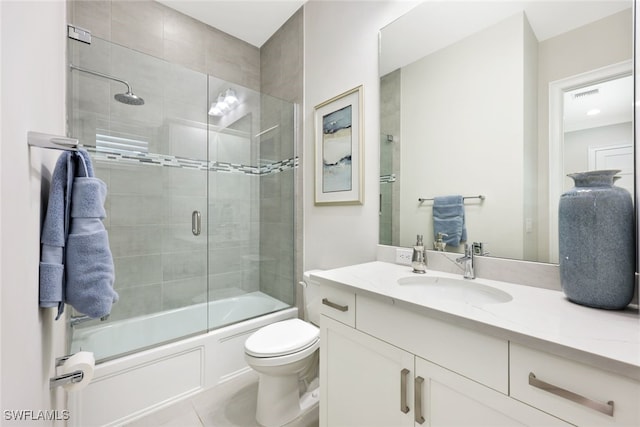 full bath with visible vents, toilet, shower / bath combination with glass door, tile patterned flooring, and vanity