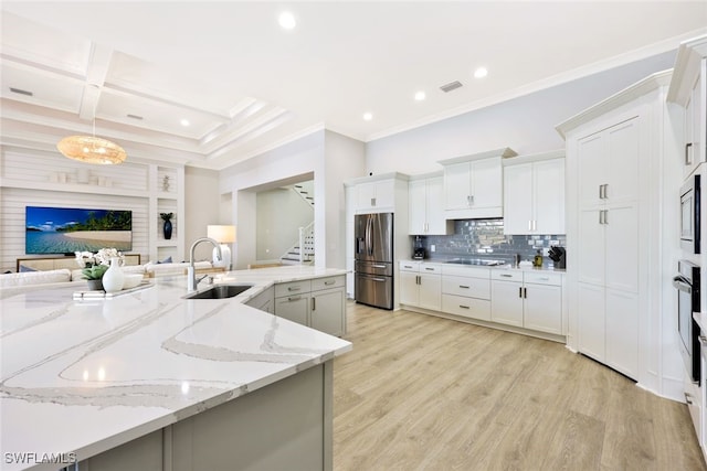 kitchen featuring crown molding, light wood-style floors, stainless steel fridge, coffered ceiling, and a sink