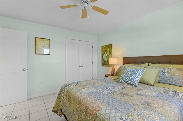 bedroom with ceiling fan, light tile patterned floors, and a closet