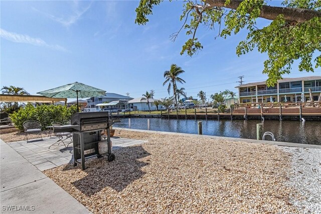 dock area with a patio and a water view