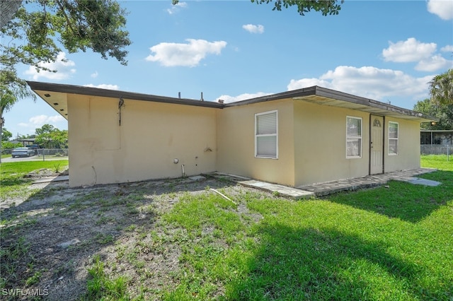 rear view of property featuring a yard